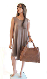 a female mannequin holding a brown purse