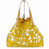 a yellow purse with white paint splattered on it