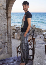 a man standing on top of a wooden table next to the ocean