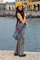 a woman in a yellow hat is standing by the water