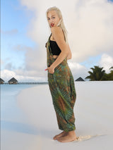 a woman standing on a beach in a tie dye jumpsuit