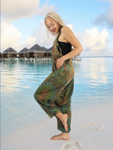 a woman standing on a beach in a dress