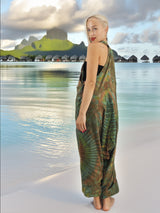 a woman standing on a beach in a dress
