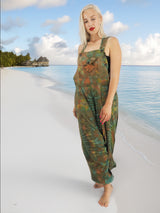 a woman standing on a beach in a green dress