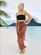 a woman standing on a beach next to a palm tree