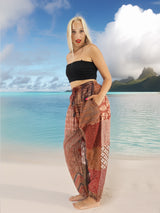 a woman standing on a beach wearing a skirt
