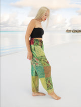 a woman standing on a beach wearing a crop top and pants