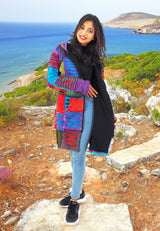 a woman standing on top of a rock near the ocean