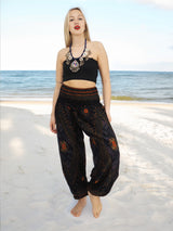 a woman standing on a beach wearing a crop top and pants