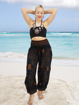 a woman standing on a beach with her hands behind her head