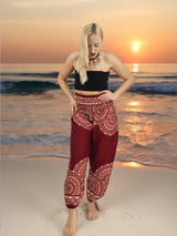a woman is standing on the beach at sunset