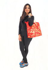 a woman is holding a red bag and posing for a picture