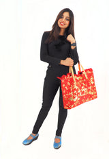 a woman holding a red bag and posing for a picture