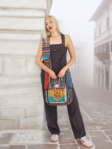 Boho-style handmade cotton hemp cross body bag featuring intricate embroidery and a colorful patchwork design, carried by a model in a misty cityscape.