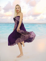 a woman in a purple dress on the beach