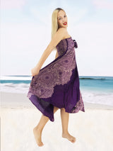 a woman in a purple dress is walking on the beach