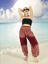 a woman standing on a beach with her arms behind her head