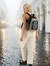 Handmade cotton hemp backpack with a unique embroidered pattern, worn by a model in a misty European-style street, perfect for travel and school.