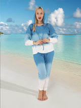 a woman in a blue and white outfit standing on a beach