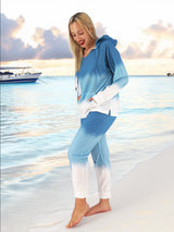 a woman standing on the beach in a blue and white outfit