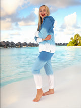 a woman in a blue and white outfit standing on a beach