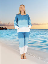a woman standing on a beach in a blue and white outfit