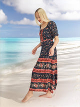 a woman standing on a beach wearing a dress