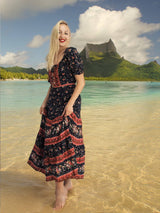 a woman standing in shallow water on a beach