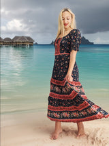 a woman in a long dress standing on a beach