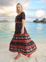 a woman standing on a beach in a dress