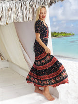a woman in a long dress standing on a beach