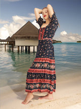 a woman in a long dress standing on a beach