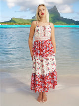 a woman standing on a beach in a red and white dress