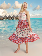 a woman in a red and white dress standing on a beach