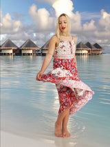 a woman in a red and white dress standing on a beach