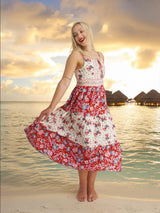 a woman in a red and white dress standing on a beach