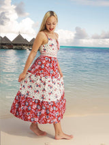 a woman in a red and white dress standing on a beach