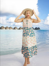 a woman standing on a beach with a hat on her head