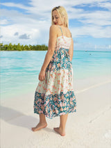 a woman standing on a beach in a dress