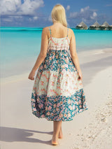 a woman standing on a beach in a dress