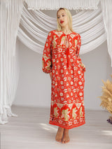 a woman in a red dress standing in front of a white backdrop