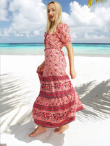 a woman in a dress standing on a beach
