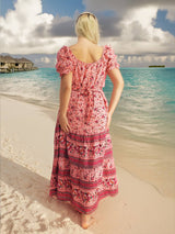 a woman standing on a beach looking at the ocean