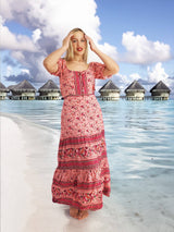 a woman in a pink dress standing on a beach