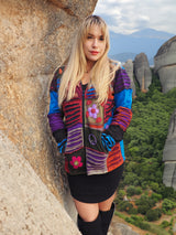 a woman standing on top of a mountain next to a cliff