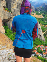 a woman standing on top of a cliff overlooking a valley