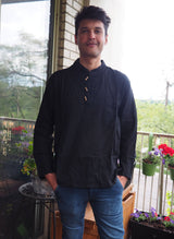 a man standing on a porch next to flowers