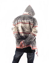 a man in a hoodie standing in front of a white background