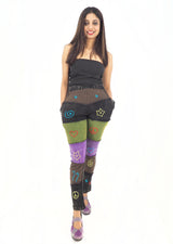 a woman in a black top and colorful pants