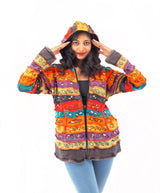 a woman wearing a colorful jacket and jeans